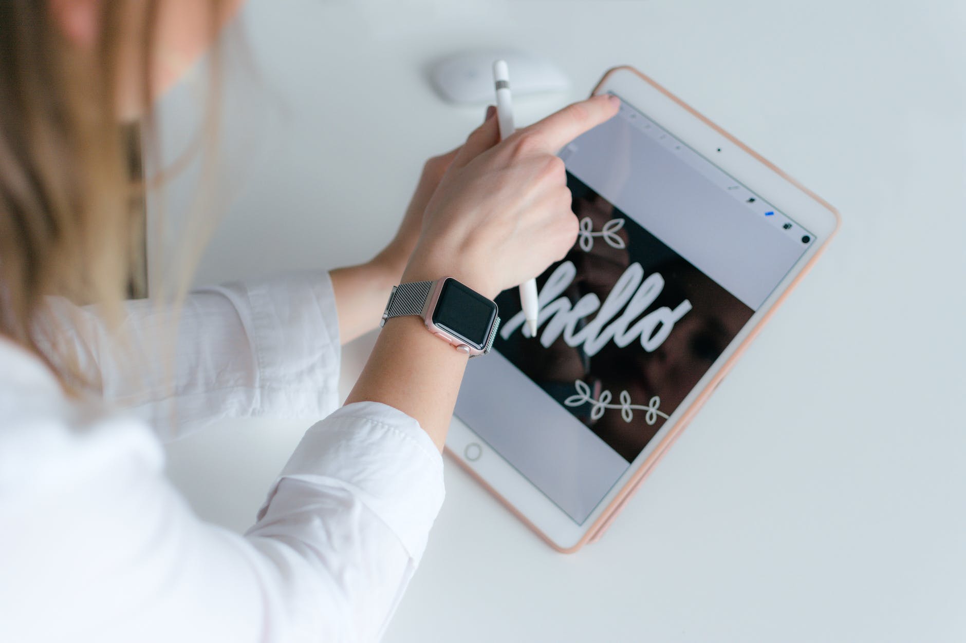 woman with applewatch holding gold ipad and apple pencil