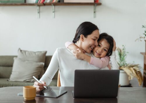 cute little ethnic girl embracing working mother