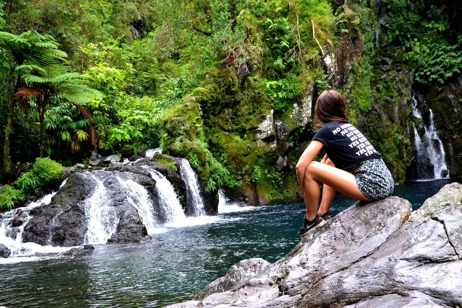 photo of woman sitting on rock