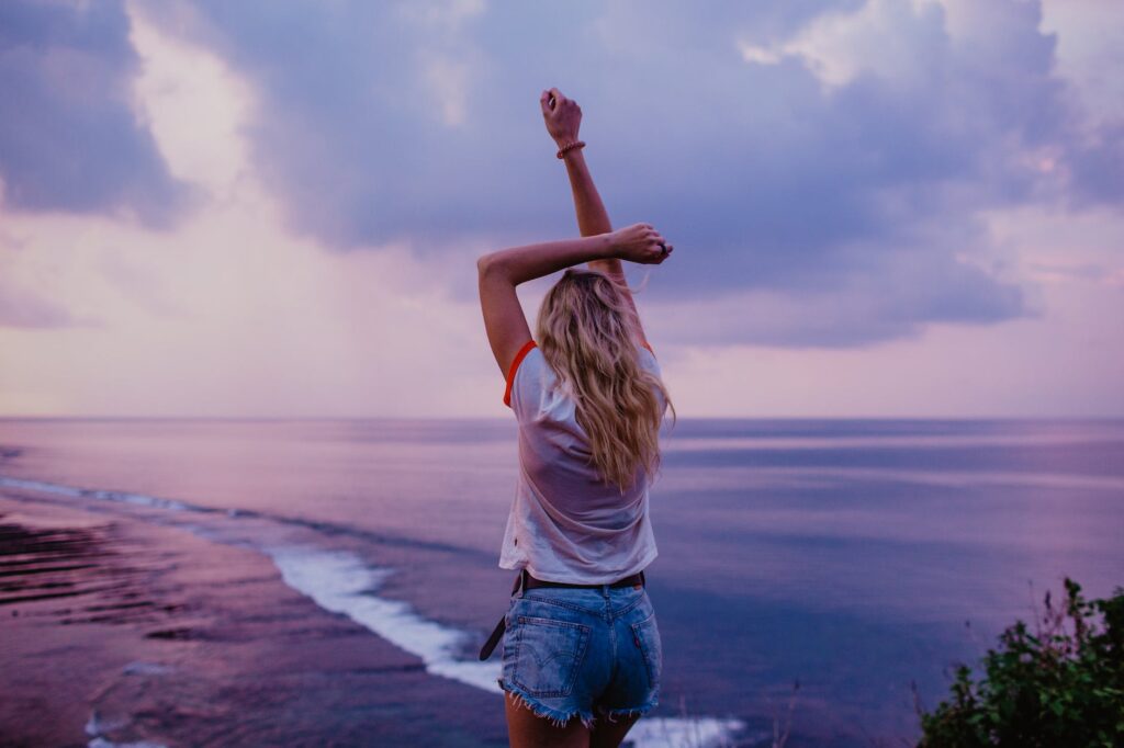 slim woman enjoying endless seascape on beach