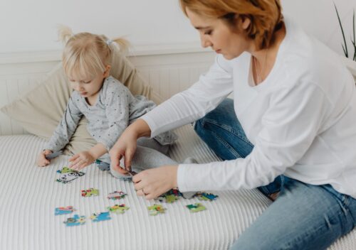 woman and a girl doing a puzzle