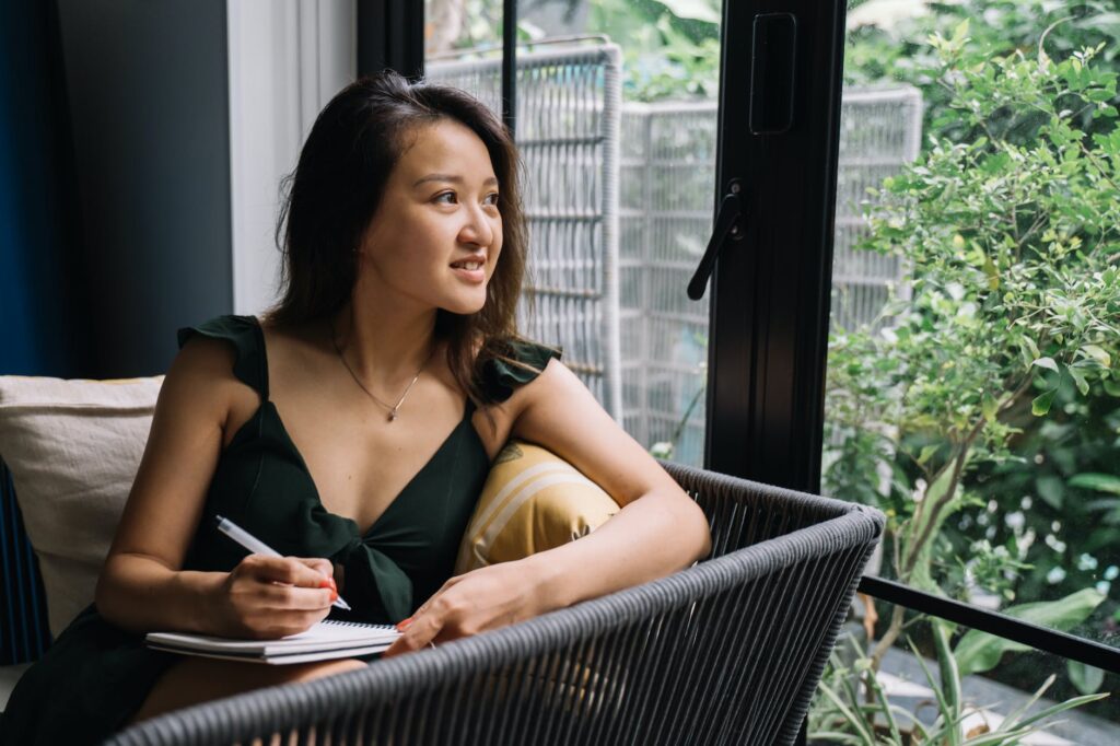 young woman sitting on a couch with a notepad