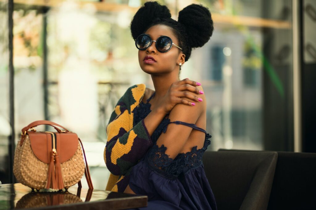 shallow focus photography of woman wearing gray and yellow spaghetti strap dress sitting on chair